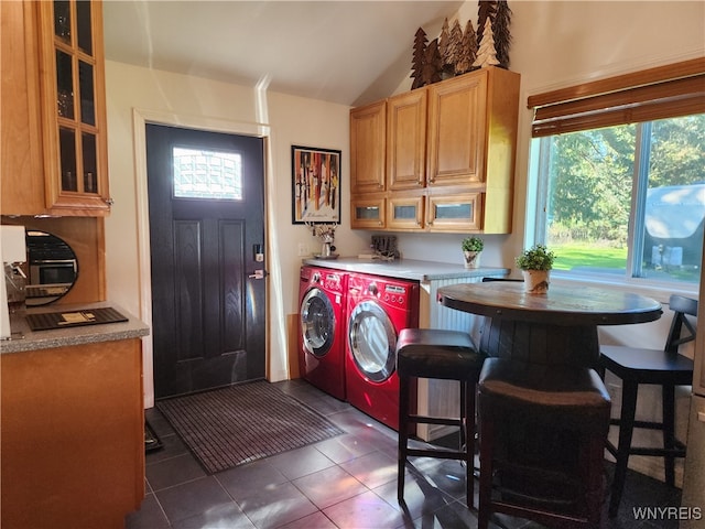 laundry area with dark tile patterned flooring and washing machine and dryer