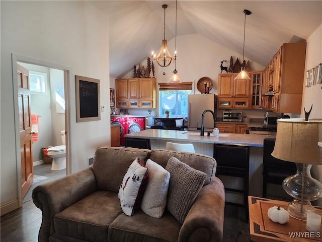 kitchen with decorative light fixtures, white refrigerator, dark hardwood / wood-style floors, and a kitchen breakfast bar