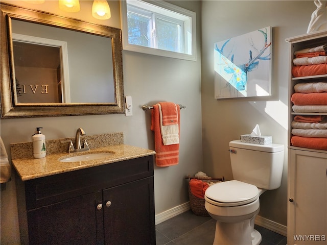 bathroom with toilet, vanity, and tile patterned floors