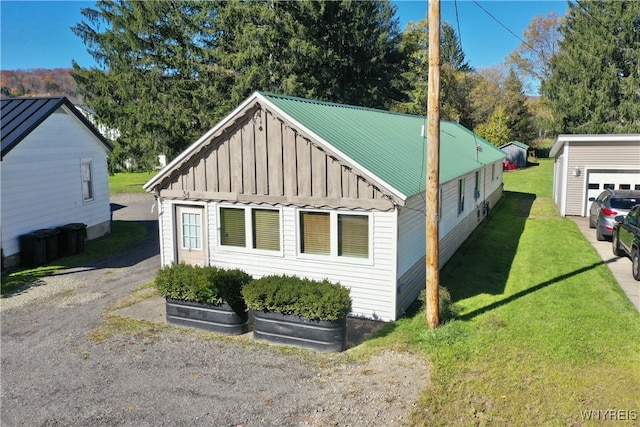 view of home's exterior with a garage, an outbuilding, and a lawn