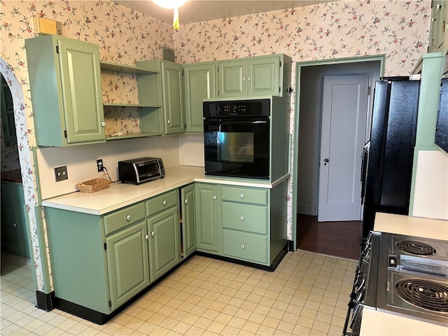 kitchen featuring green cabinets, black oven, and range with electric stovetop