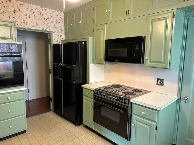 kitchen featuring green cabinets, black appliances, and light tile patterned floors