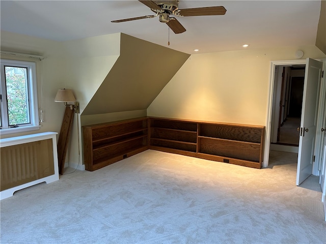 bonus room featuring lofted ceiling, ceiling fan, radiator heating unit, and light colored carpet