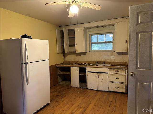 kitchen featuring sink, white fridge, light wood-type flooring, and ceiling fan