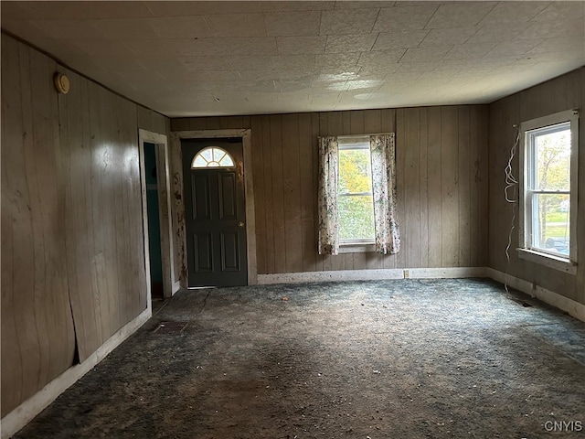 foyer entrance featuring wood walls and a healthy amount of sunlight