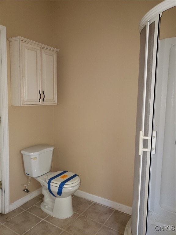 bathroom featuring toilet and tile patterned flooring