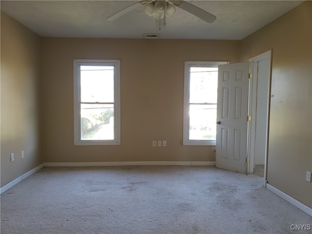 carpeted spare room featuring ceiling fan