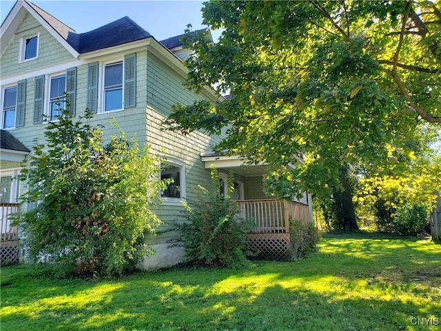 view of property exterior with a yard and a deck