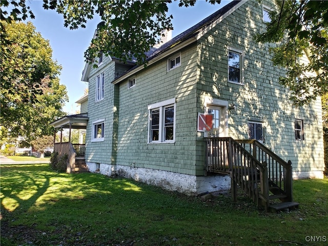 view of side of home with a yard