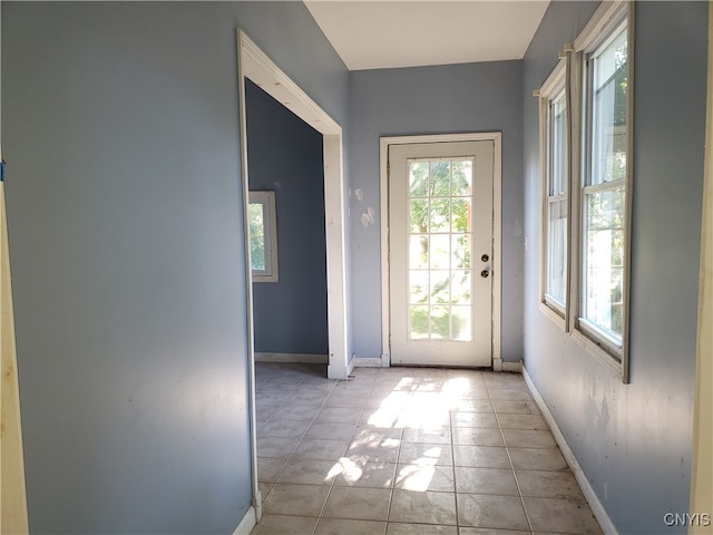 doorway to outside with light tile patterned floors