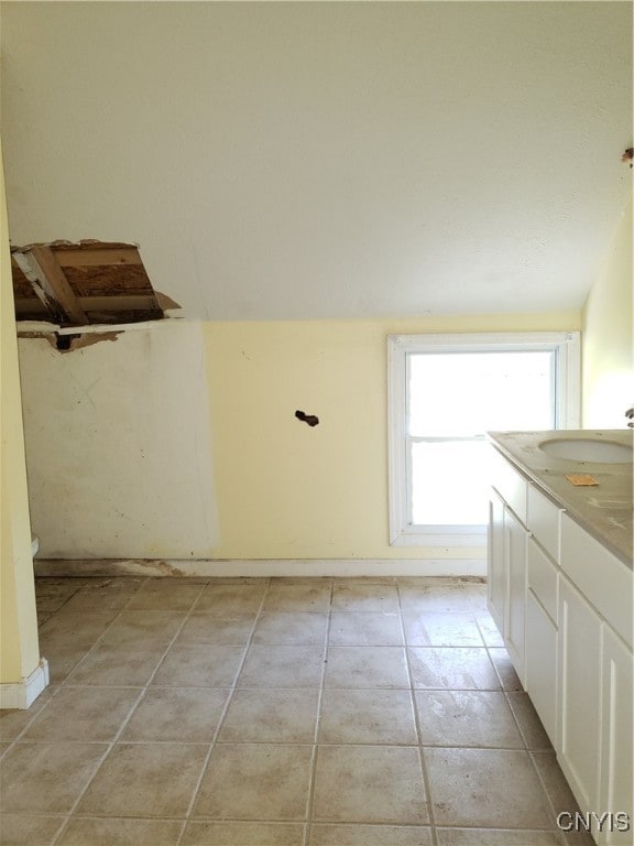 bathroom featuring vanity, lofted ceiling, and tile patterned floors