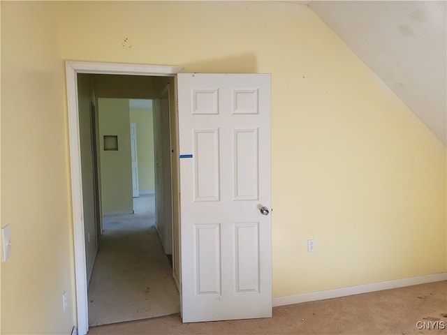 hallway featuring carpet flooring and lofted ceiling