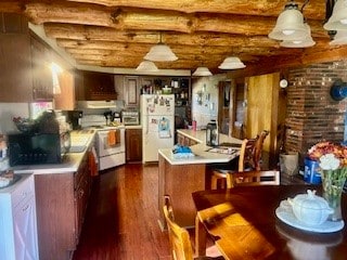 kitchen featuring dark wood-type flooring, a breakfast bar, white appliances, and extractor fan