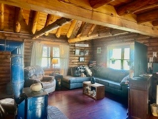 living room with wooden ceiling, dark hardwood / wood-style flooring, plenty of natural light, and rustic walls