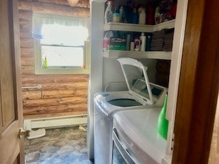 clothes washing area with log walls, washing machine and clothes dryer, and baseboard heating