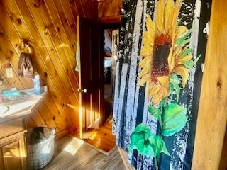 bathroom with hardwood / wood-style floors and wood walls