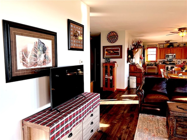 living room featuring ceiling fan and dark hardwood / wood-style floors