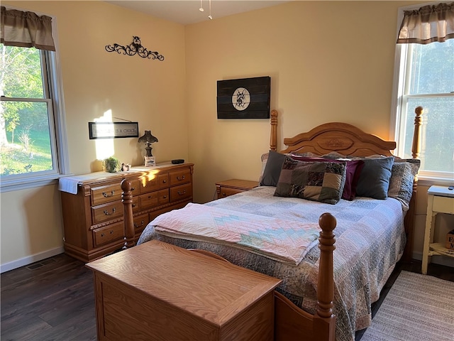 bedroom with dark wood-type flooring and multiple windows