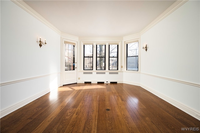 spare room featuring ornamental molding and hardwood / wood-style flooring