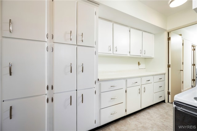 kitchen featuring white cabinetry, white electric stove, and light tile patterned flooring