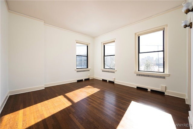 spare room featuring ornamental molding and dark hardwood / wood-style flooring