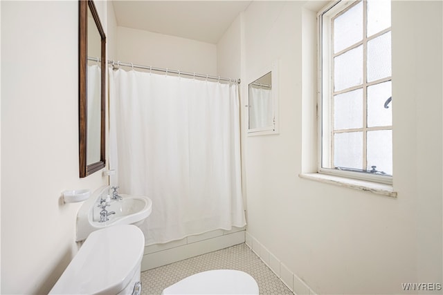 bathroom featuring toilet, a healthy amount of sunlight, a shower with shower curtain, and tile patterned flooring