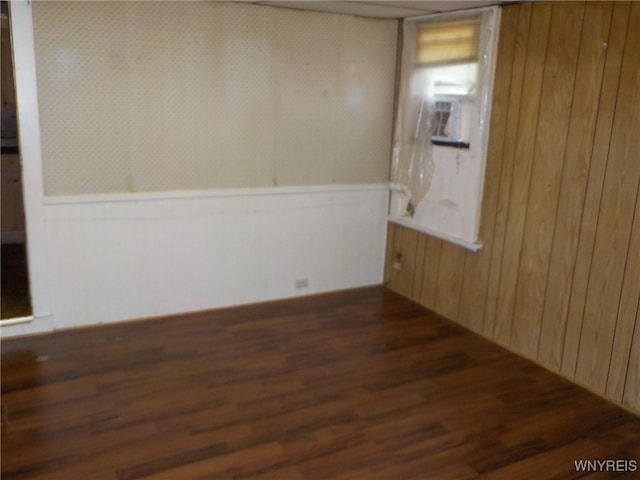 empty room featuring wood walls, cooling unit, and dark hardwood / wood-style flooring