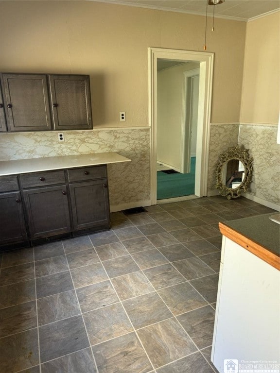 kitchen featuring dark brown cabinetry and ornamental molding