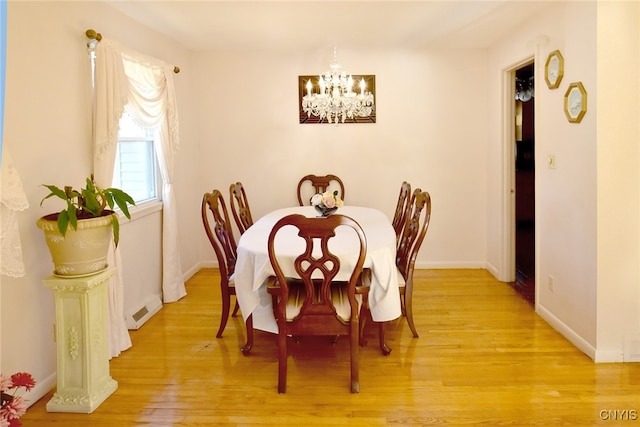 dining space with a chandelier and light hardwood / wood-style flooring