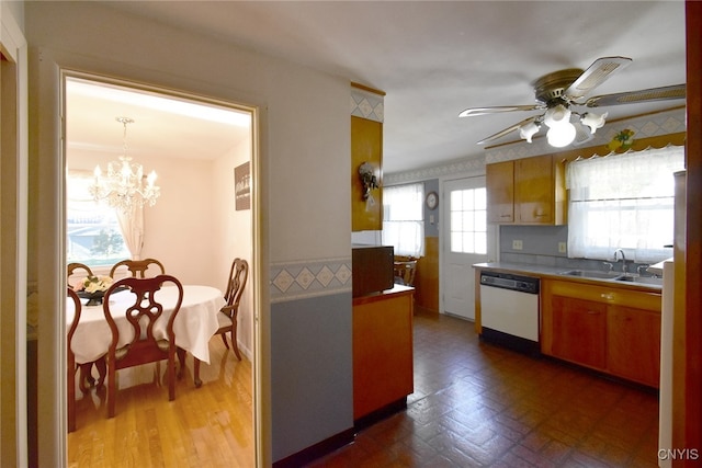 kitchen featuring dishwasher, a wealth of natural light, sink, and ceiling fan with notable chandelier