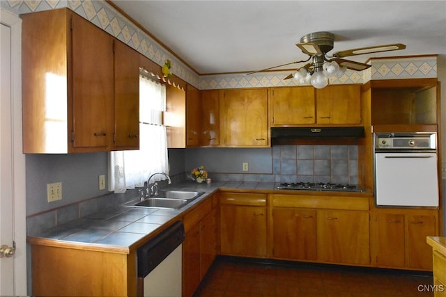 kitchen featuring sink, tasteful backsplash, ceiling fan, white appliances, and tile counters