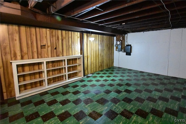 basement with electric panel and wood walls