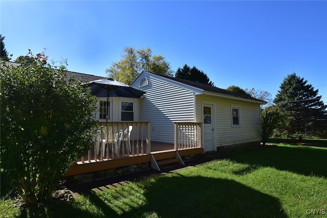 back of property with a lawn and a deck