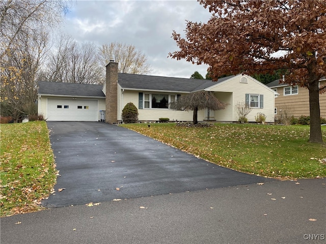 ranch-style house featuring a garage and a front lawn