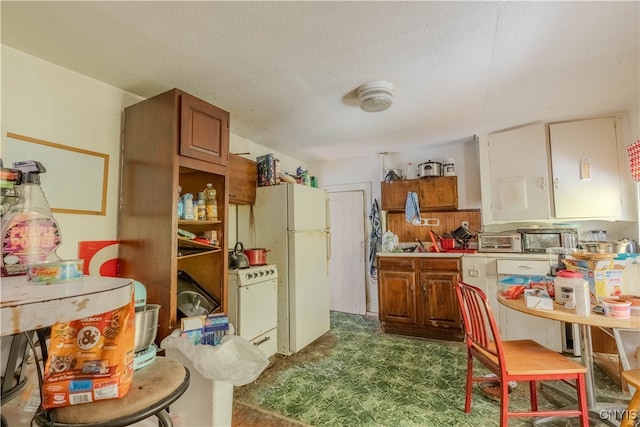 kitchen featuring a textured ceiling and white appliances