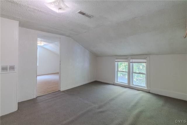 bonus room with lofted ceiling, a textured ceiling, and carpet flooring