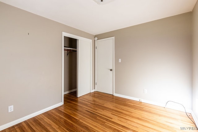 unfurnished bedroom featuring wood-type flooring and a closet