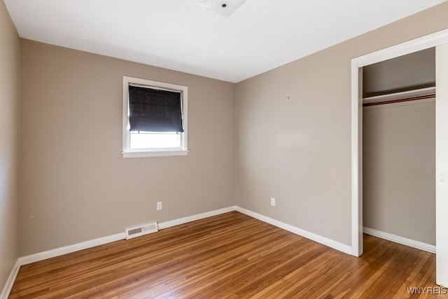 unfurnished bedroom with wood-type flooring and a closet