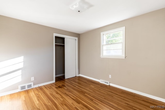 unfurnished bedroom with hardwood / wood-style floors and a closet