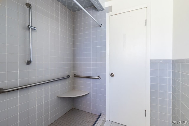 bathroom with tile walls and tiled shower