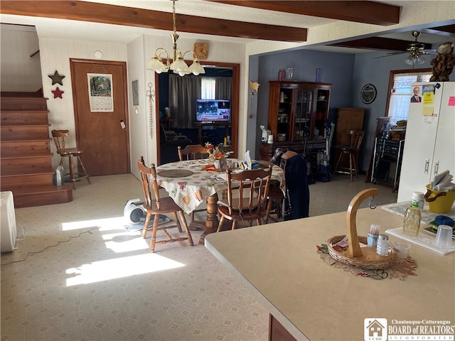 dining space with beamed ceiling and ceiling fan with notable chandelier