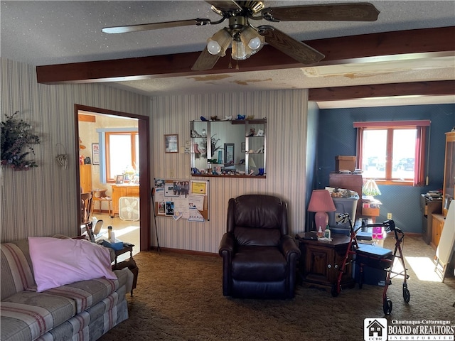 living room featuring carpet flooring, beamed ceiling, a textured ceiling, and ceiling fan