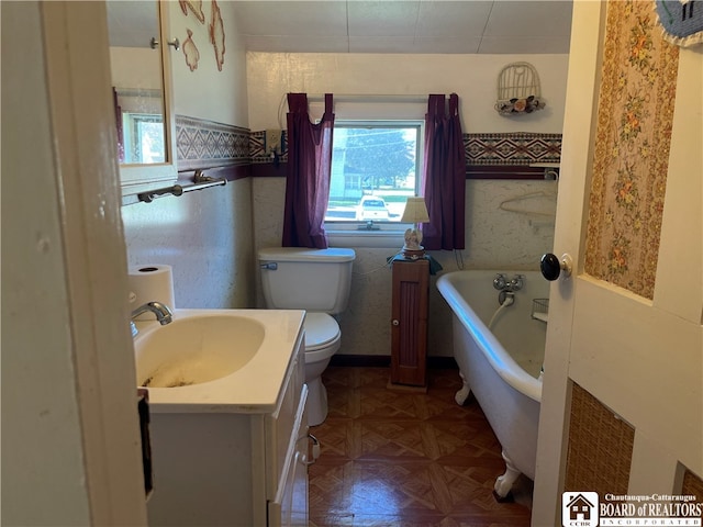 bathroom with toilet, a bathtub, parquet floors, vanity, and tile walls