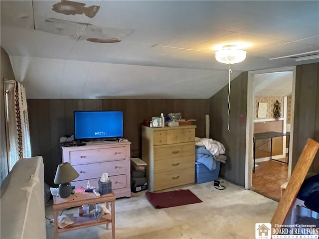 carpeted bedroom featuring wood walls and vaulted ceiling