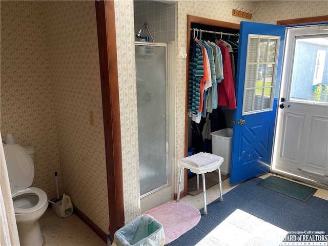 bathroom with toilet and a shower with shower door