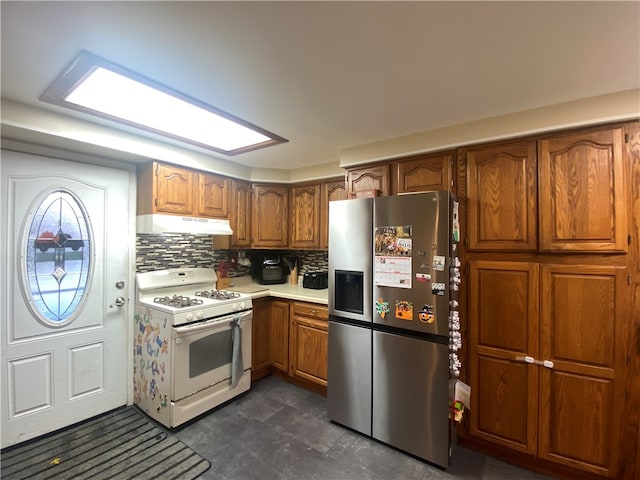 kitchen featuring decorative backsplash, white gas range, and stainless steel fridge with ice dispenser