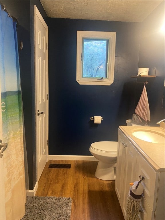 bathroom featuring vanity, hardwood / wood-style floors, a shower with curtain, and toilet