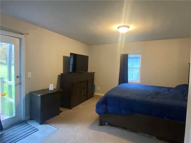 bedroom with light carpet and multiple windows