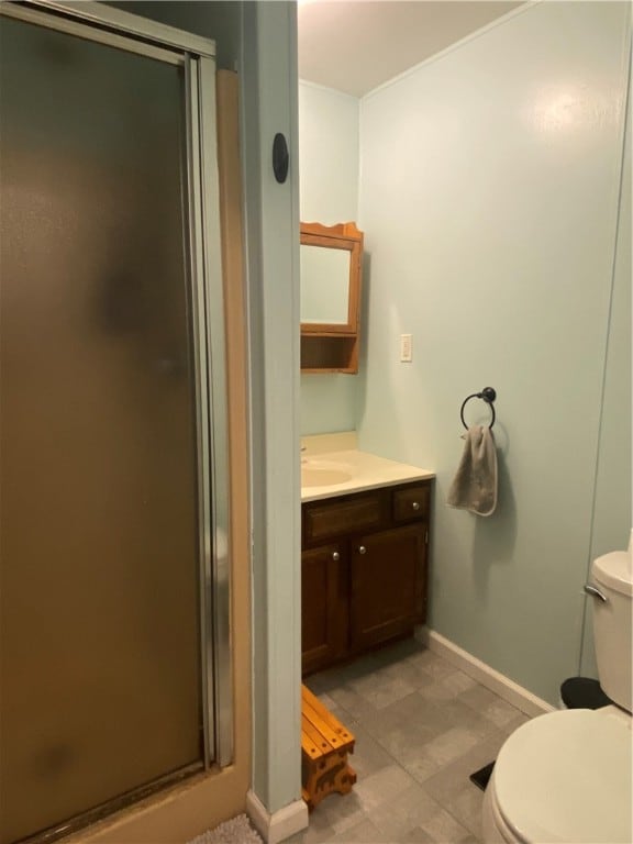 bathroom featuring vanity, toilet, and a shower with shower door