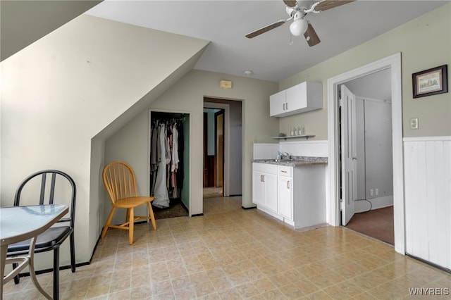 kitchen featuring sink, white cabinets, and ceiling fan